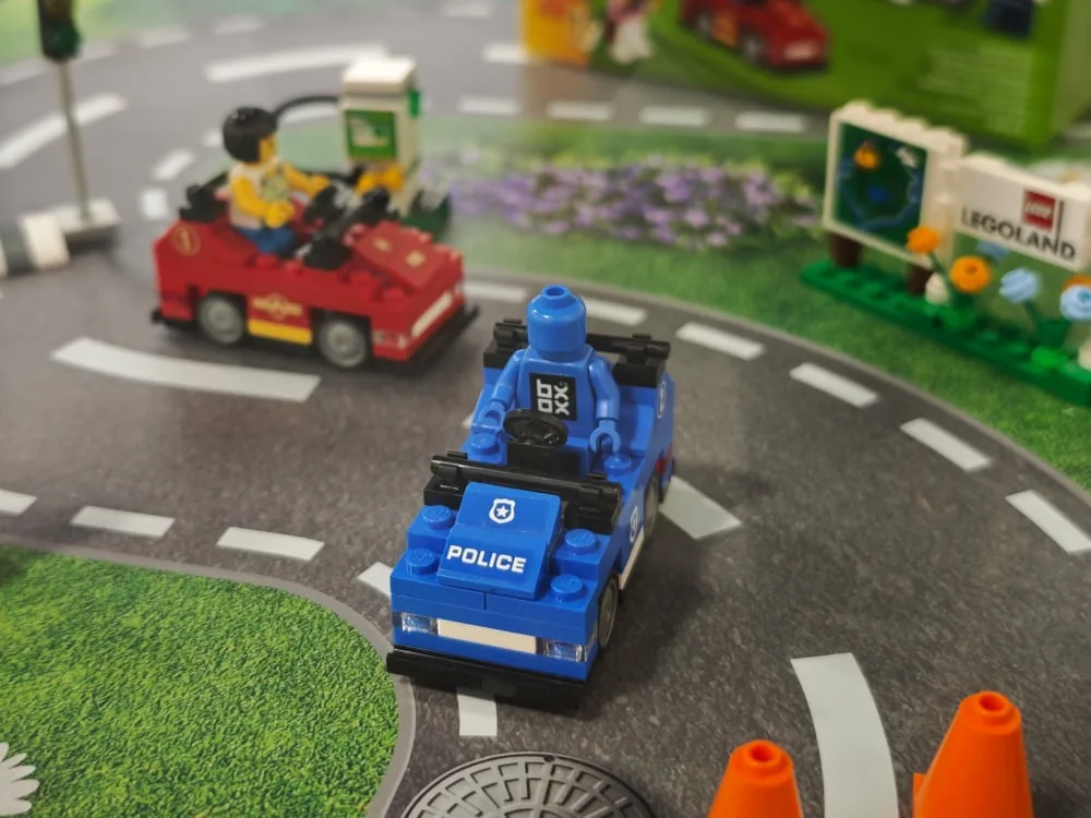 Custom printed road-layout base inside the case with LEGO cars and minifigures